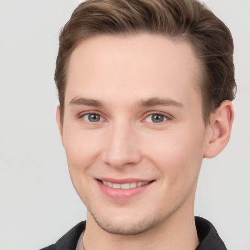 Joyful white young-adult male with short  brown hair and grey eyes