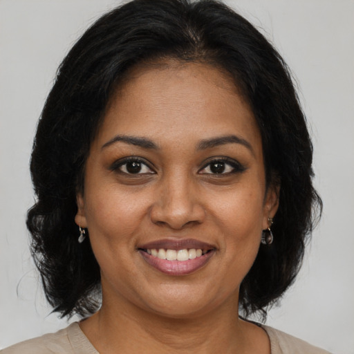 Joyful black adult female with medium  brown hair and brown eyes