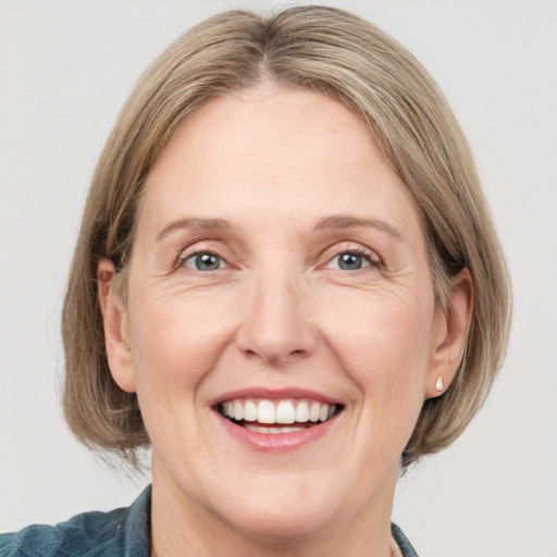 Joyful white adult female with medium  brown hair and grey eyes