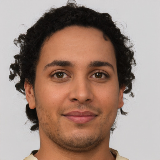 Joyful latino young-adult male with short  brown hair and brown eyes