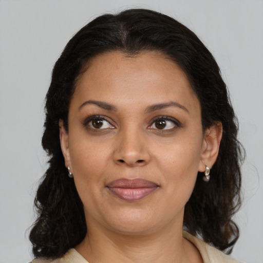 Joyful latino young-adult female with medium  brown hair and brown eyes