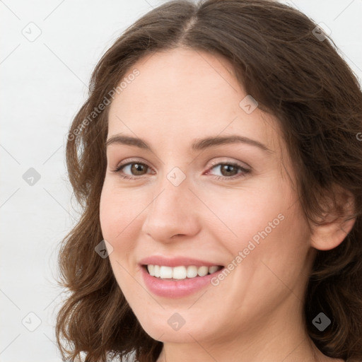 Joyful white young-adult female with long  brown hair and green eyes