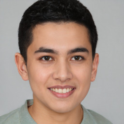 Joyful latino young-adult male with short  brown hair and brown eyes