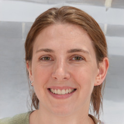 Joyful white young-adult female with medium  brown hair and blue eyes