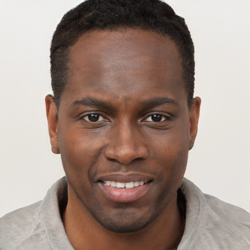 Joyful black young-adult male with short  brown hair and brown eyes