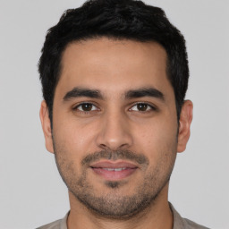 Joyful white young-adult male with short  black hair and brown eyes