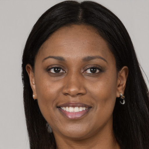 Joyful black adult female with long  black hair and brown eyes