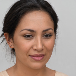 Joyful latino adult female with medium  brown hair and brown eyes