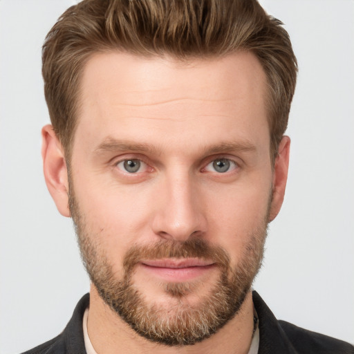 Joyful white young-adult male with short  brown hair and grey eyes