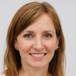 Joyful white young-adult female with long  brown hair and green eyes