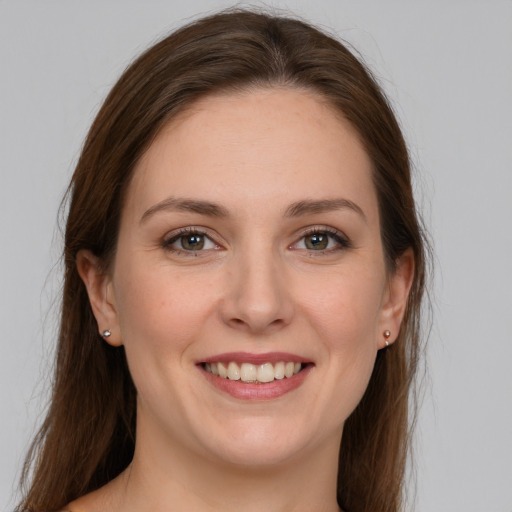 Joyful white young-adult female with long  brown hair and grey eyes