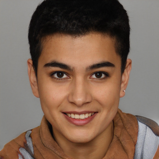 Joyful latino young-adult male with short  brown hair and brown eyes