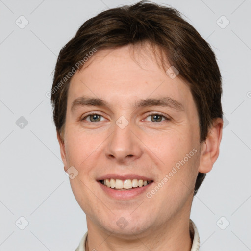 Joyful white young-adult male with short  brown hair and grey eyes