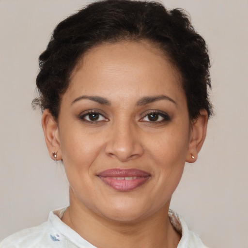 Joyful latino adult female with short  brown hair and brown eyes