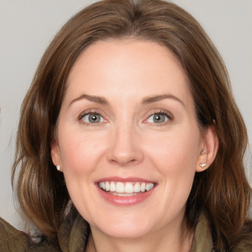 Joyful white adult female with medium  brown hair and grey eyes