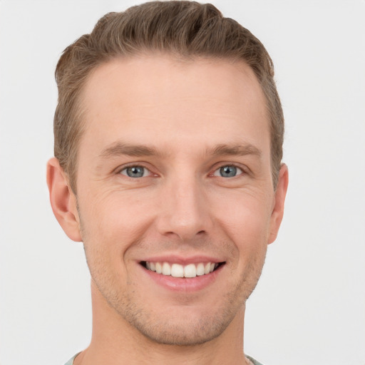 Joyful white young-adult male with short  brown hair and grey eyes