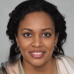 Joyful black young-adult female with long  brown hair and brown eyes