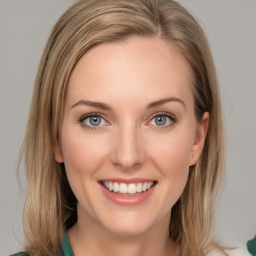 Joyful white young-adult female with medium  brown hair and green eyes