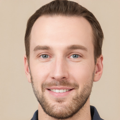 Joyful white young-adult male with short  brown hair and grey eyes