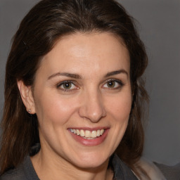 Joyful white adult female with medium  brown hair and brown eyes