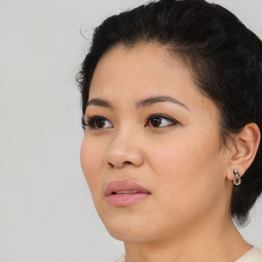 Joyful latino young-adult female with short  black hair and brown eyes