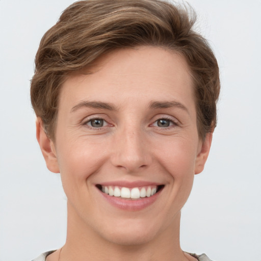 Joyful white young-adult female with short  brown hair and grey eyes