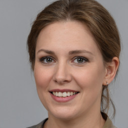 Joyful white young-adult female with medium  brown hair and grey eyes