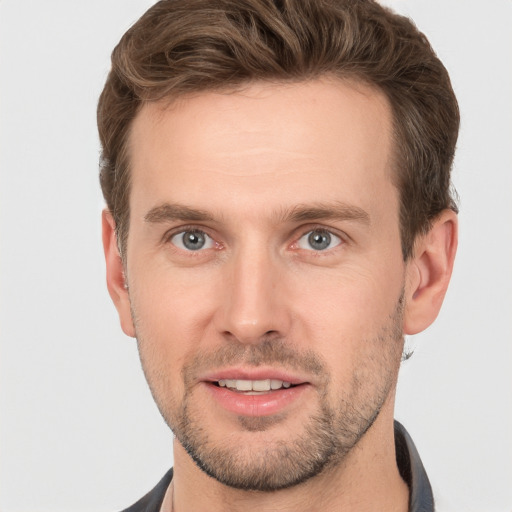 Joyful white young-adult male with short  brown hair and grey eyes