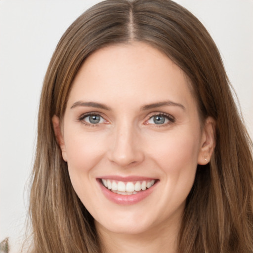 Joyful white young-adult female with long  brown hair and grey eyes