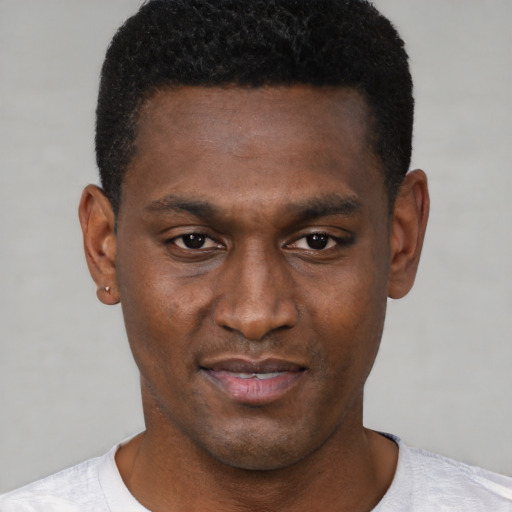 Joyful black young-adult male with short  brown hair and brown eyes