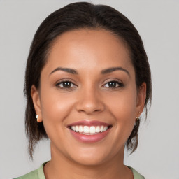 Joyful latino young-adult female with medium  brown hair and brown eyes