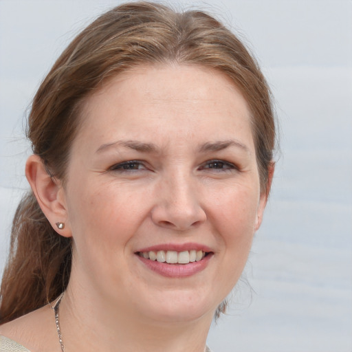 Joyful white young-adult female with medium  brown hair and grey eyes