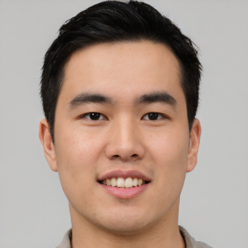 Joyful asian young-adult male with short  black hair and brown eyes