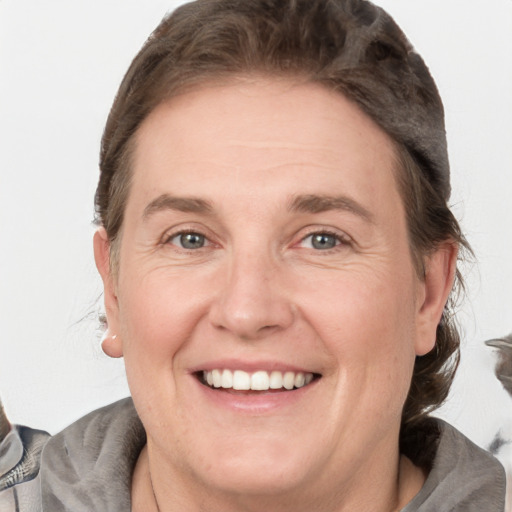 Joyful white adult female with medium  brown hair and grey eyes