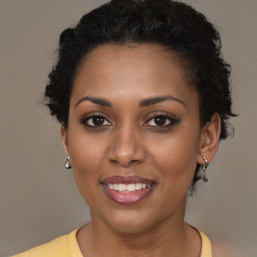 Joyful black young-adult female with short  brown hair and brown eyes