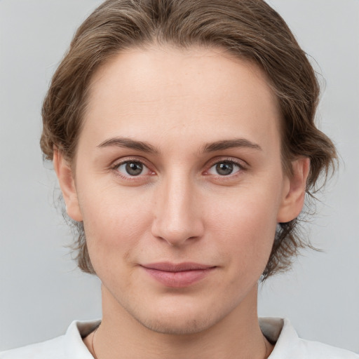 Joyful white young-adult female with medium  brown hair and grey eyes