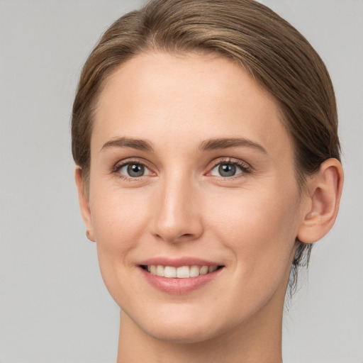 Joyful white young-adult female with medium  brown hair and grey eyes