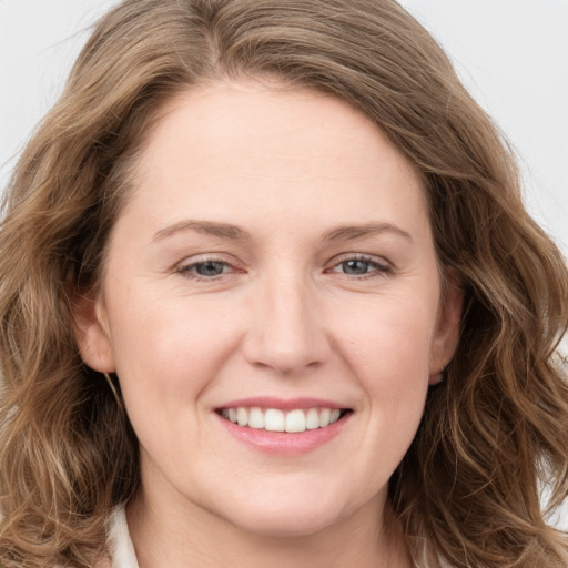 Joyful white young-adult female with long  brown hair and blue eyes