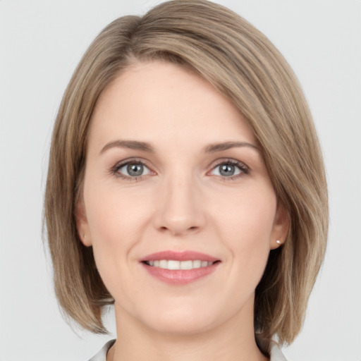 Joyful white young-adult female with medium  brown hair and grey eyes