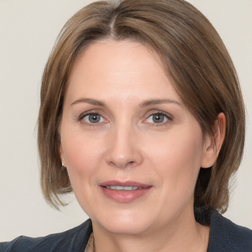 Joyful white adult female with medium  brown hair and grey eyes