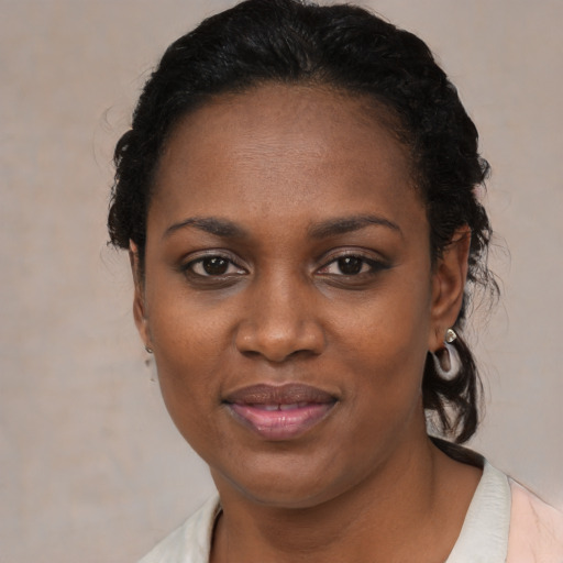 Joyful black young-adult female with short  black hair and brown eyes