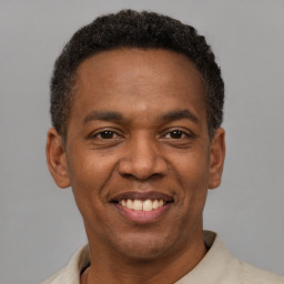 Joyful latino young-adult male with short  brown hair and brown eyes
