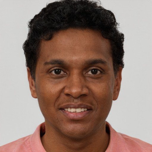 Joyful black young-adult male with short  brown hair and brown eyes