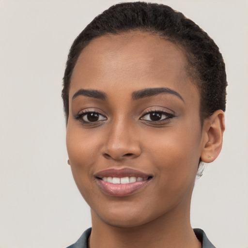 Joyful black young-adult female with short  brown hair and brown eyes