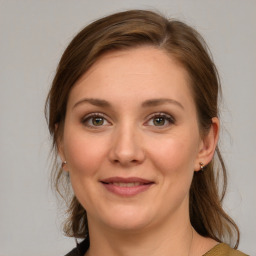 Joyful white young-adult female with medium  brown hair and grey eyes