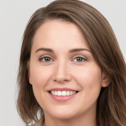 Joyful white young-adult female with long  brown hair and grey eyes