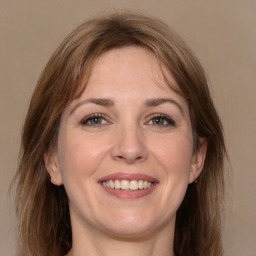 Joyful white adult female with medium  brown hair and grey eyes