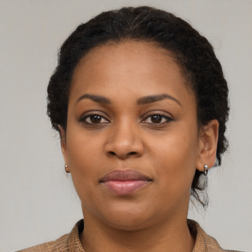 Joyful black young-adult female with medium  brown hair and brown eyes