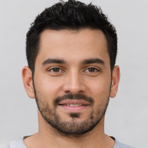 Joyful latino young-adult male with short  black hair and brown eyes