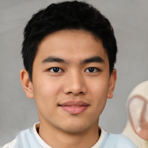 Joyful asian young-adult male with short  black hair and brown eyes
